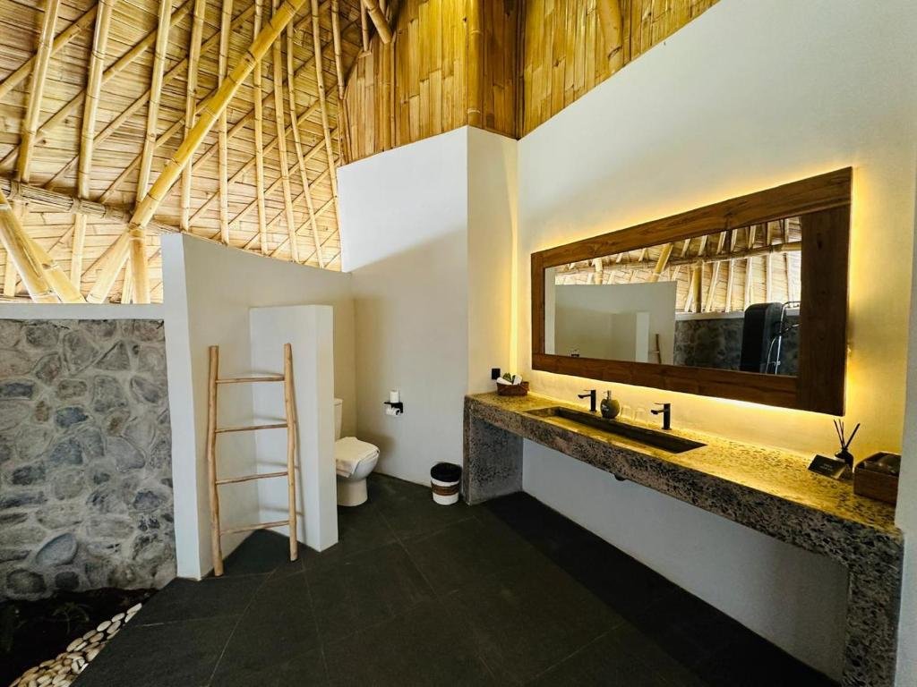 Stone bathroom with lit mirror